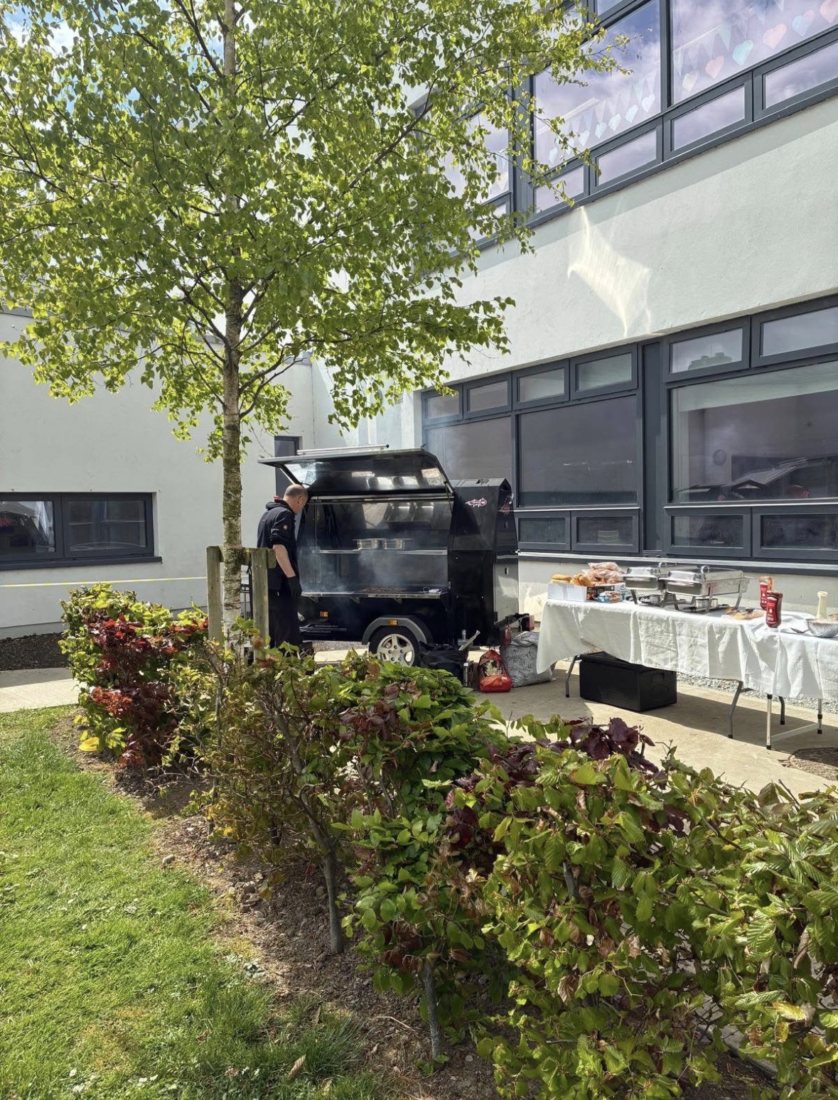 Pink Pepper BBQ trailer set up beside a long buffet table